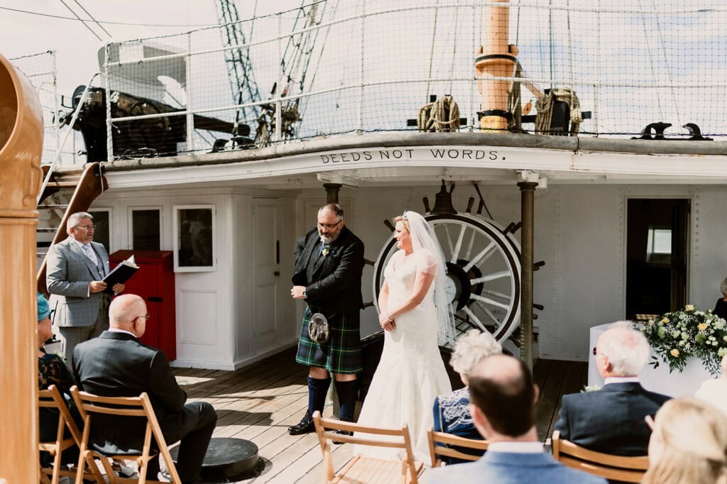Wedding ceremony on a historic ship deck.