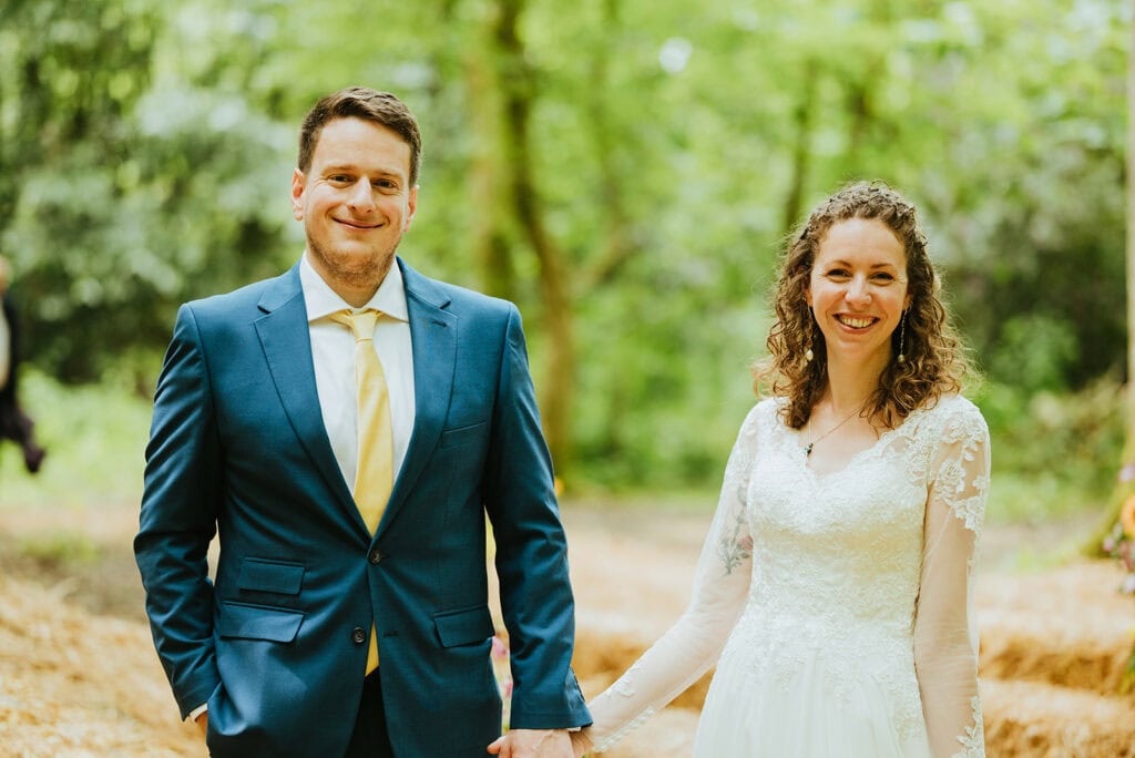 Bride and groom holding hands outdoors.