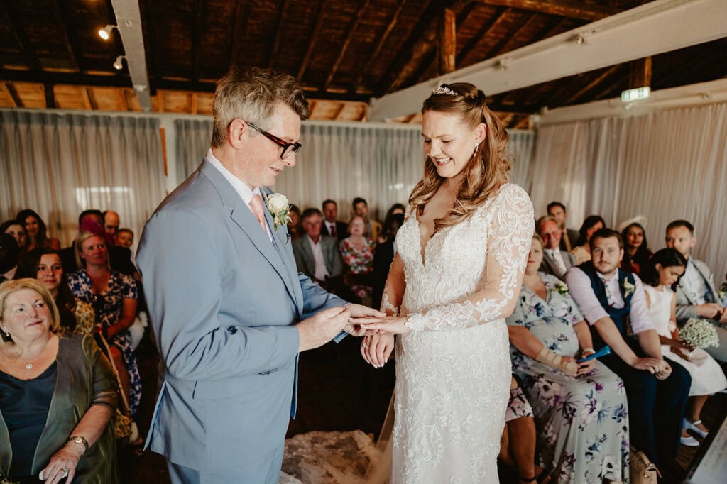 Couple exchanging rings during wedding ceremony.
