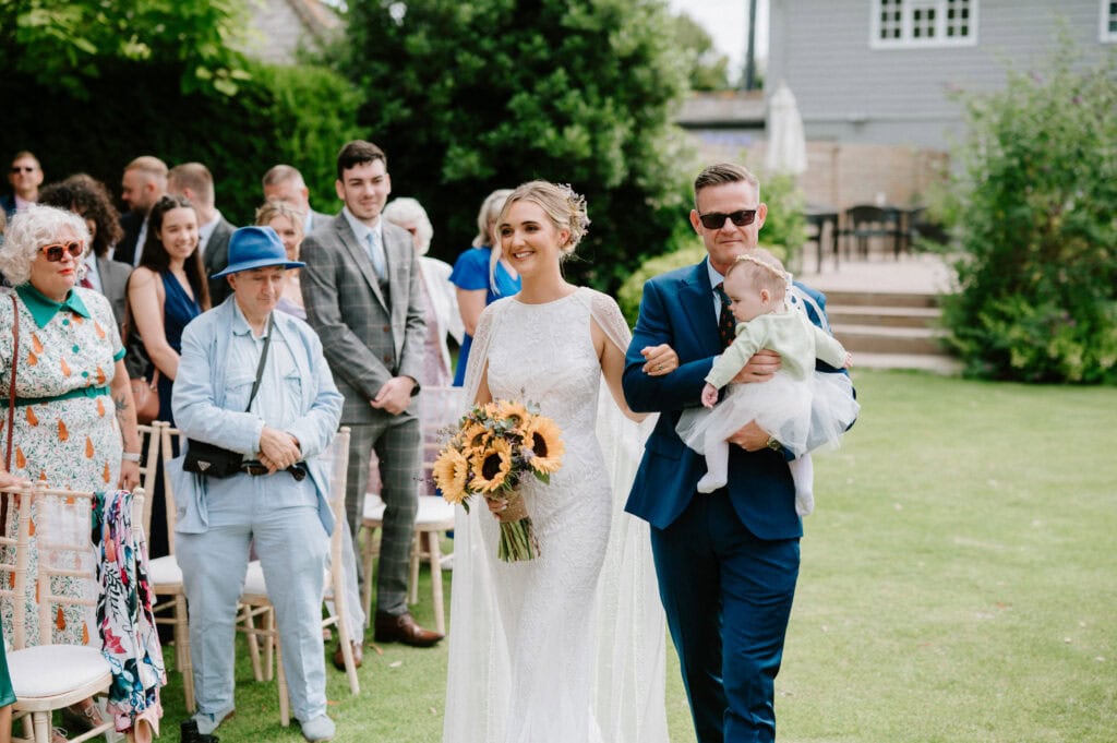 Bride walking down aisle with guests.