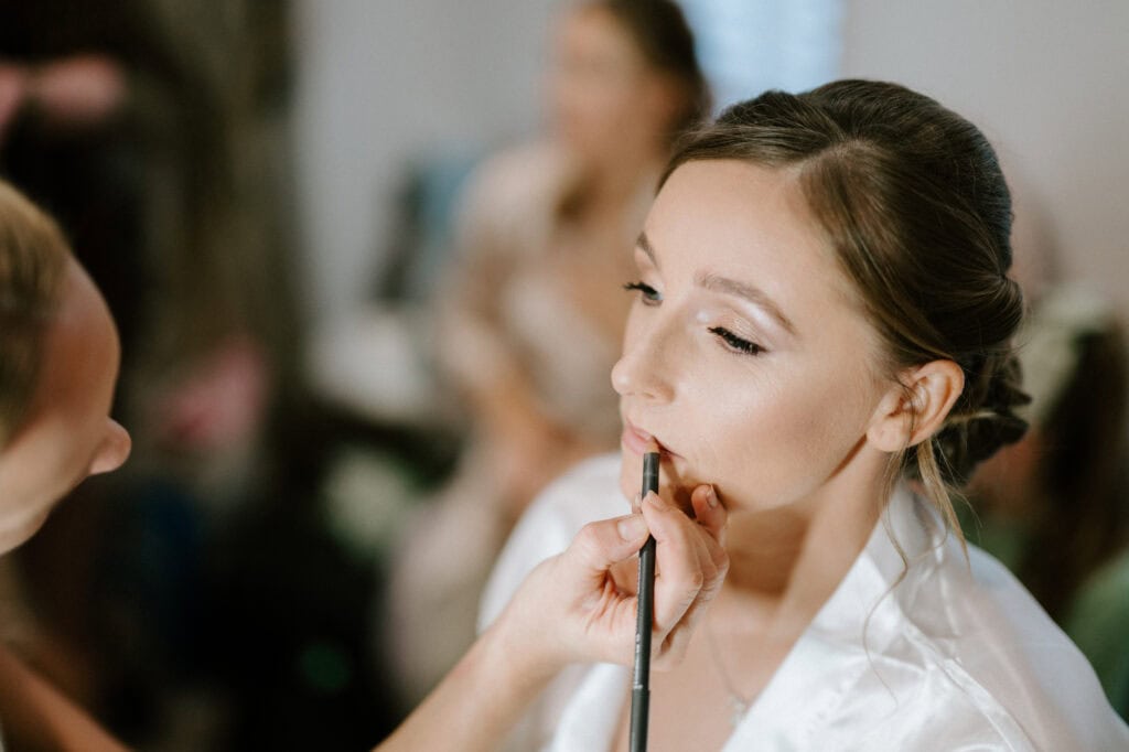 Woman getting makeup applied for wedding day.