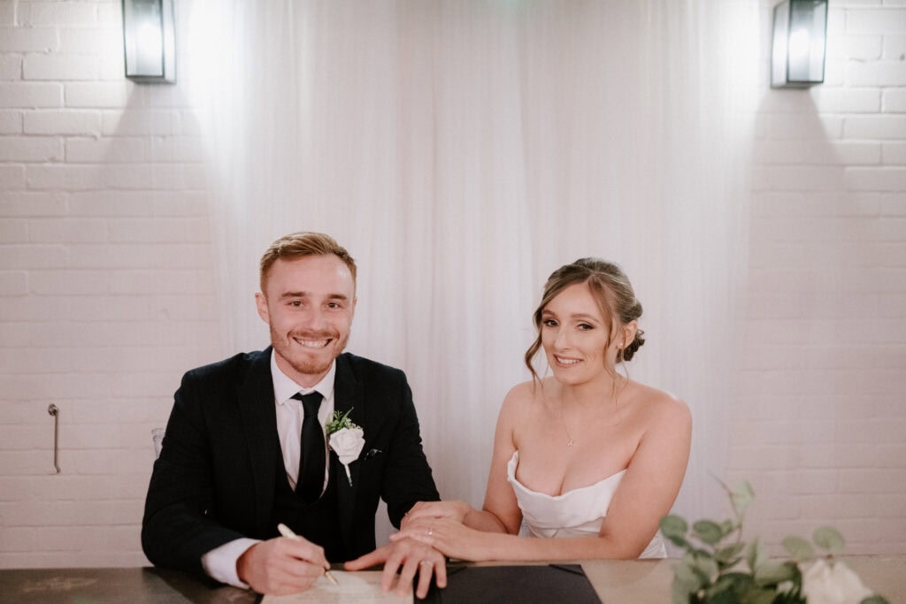 Bride and groom signing wedding certificate.