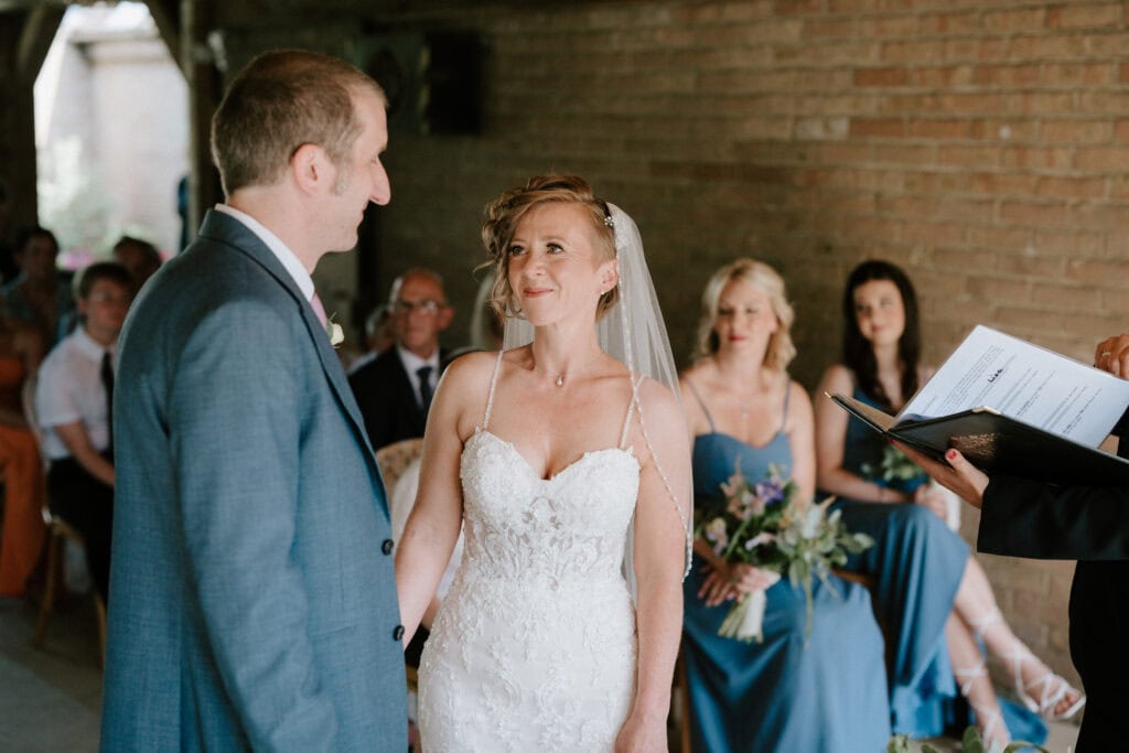 Bride and groom exchanging wedding vows inside chapel.