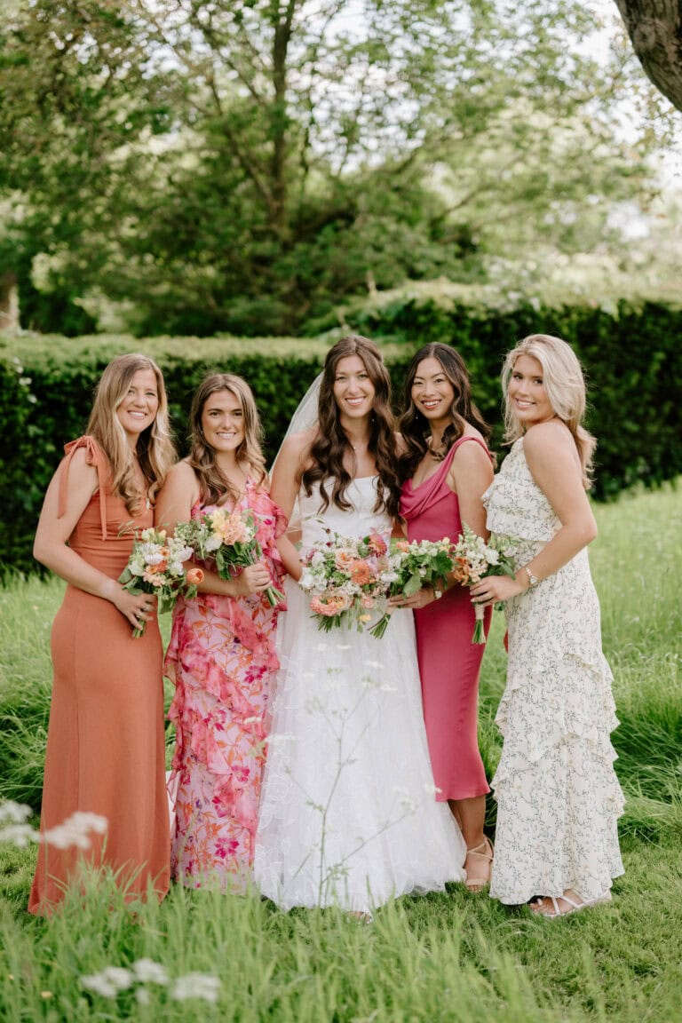Bride and bridesmaids in garden with bouquets