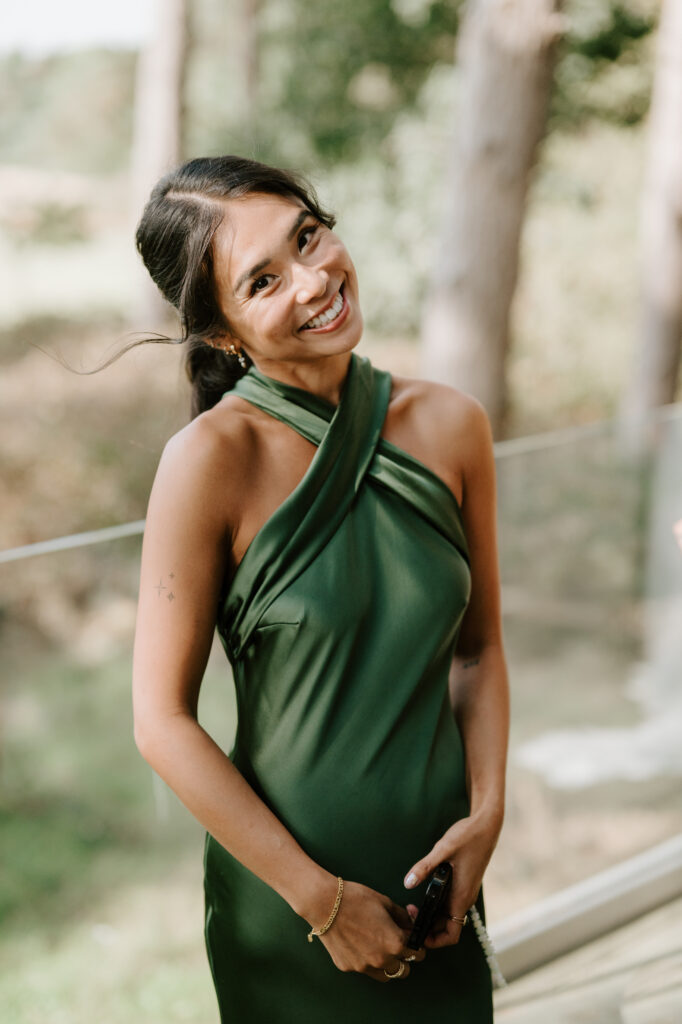 Smiling woman in elegant green dress outdoors.