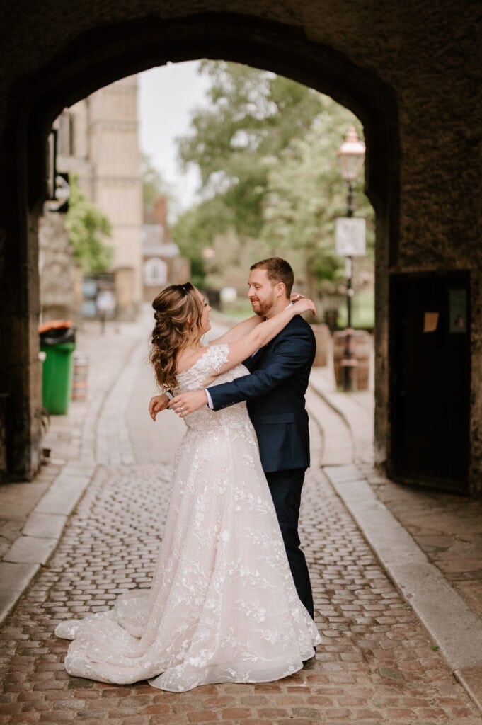 Couple embracing under a stone archway