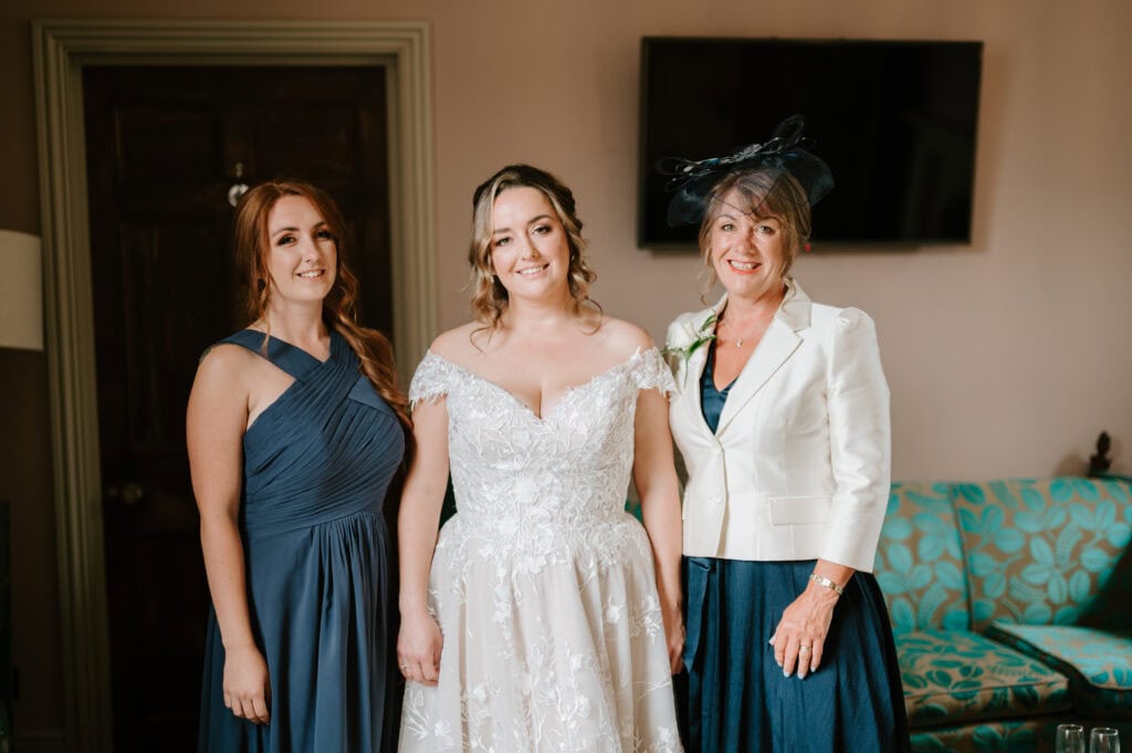 Smiling bride with bridesmaid and mother.