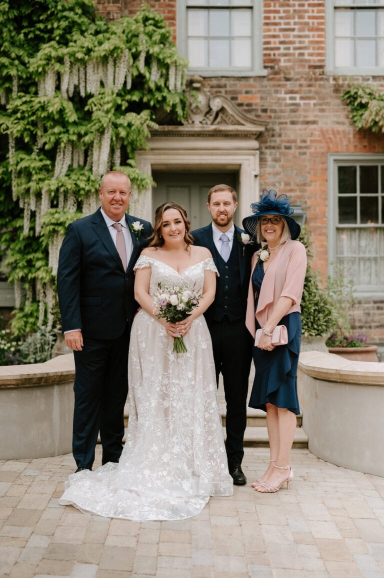 Wedding couple with family in garden setting.