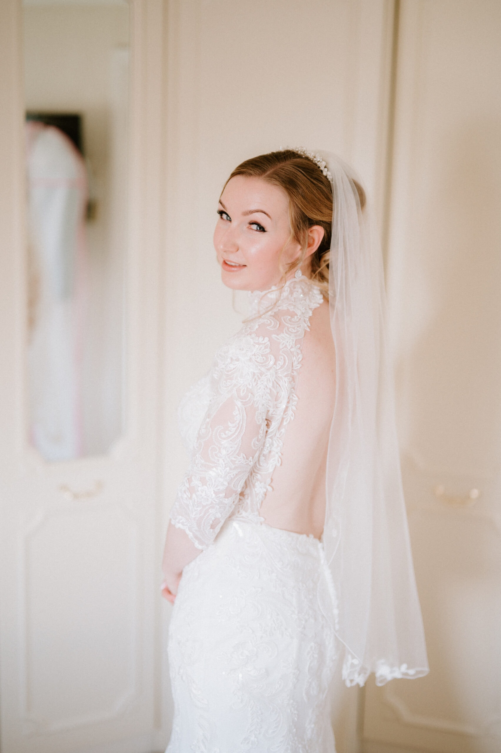 Bride in lace gown and veil, smiling