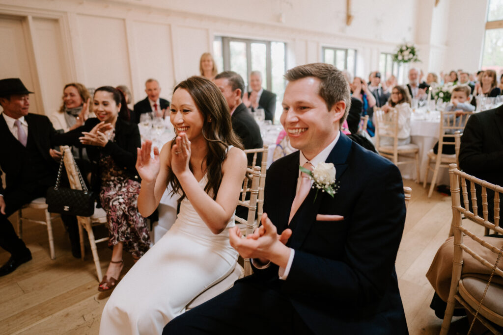 Bride and groom clapping during wedding reception.