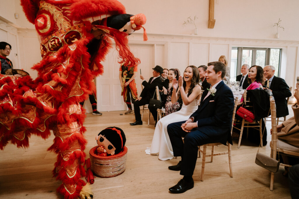 Wedding guests enjoying traditional Chinese lion dance performance.