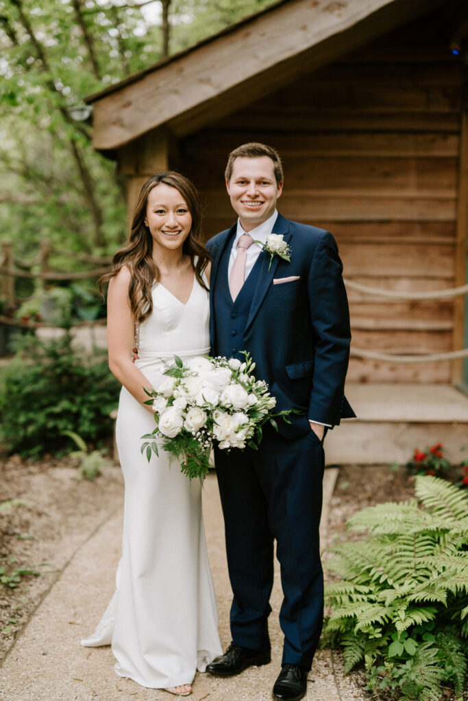 Bride and groom smiling outdoors at their wedding.