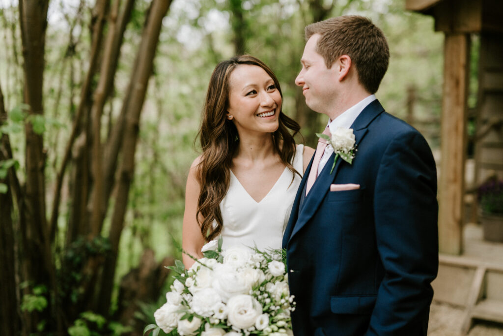 Bride and groom smiling in a forest.