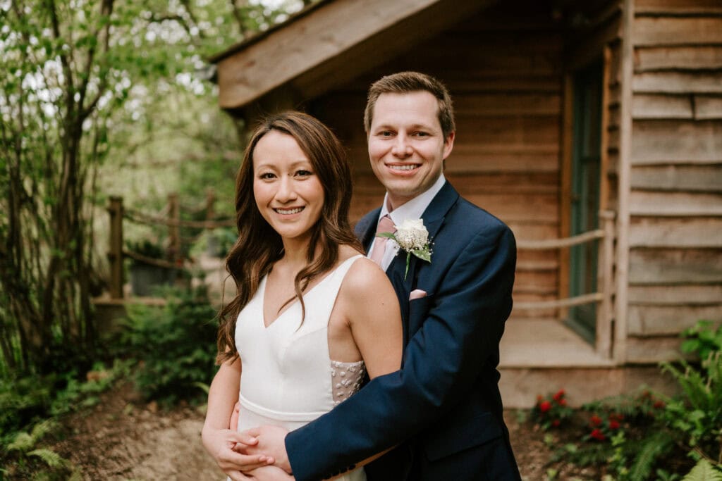 Bride and groom smiling in garden.