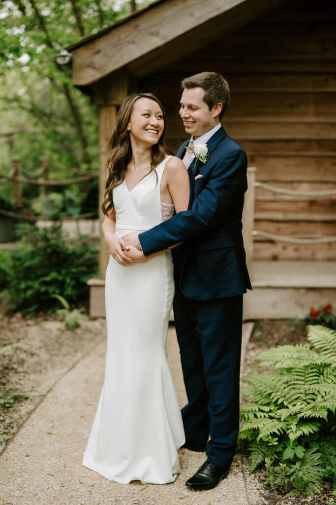 Bride and groom smiling outdoors on wedding day.