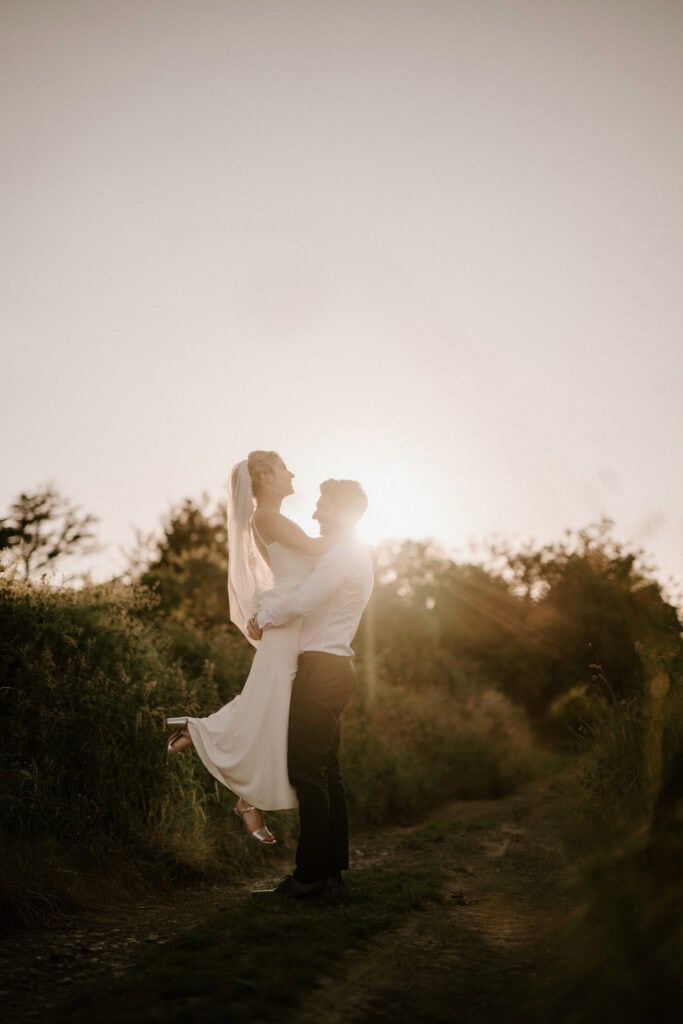 Bride and groom at sunset on country path.