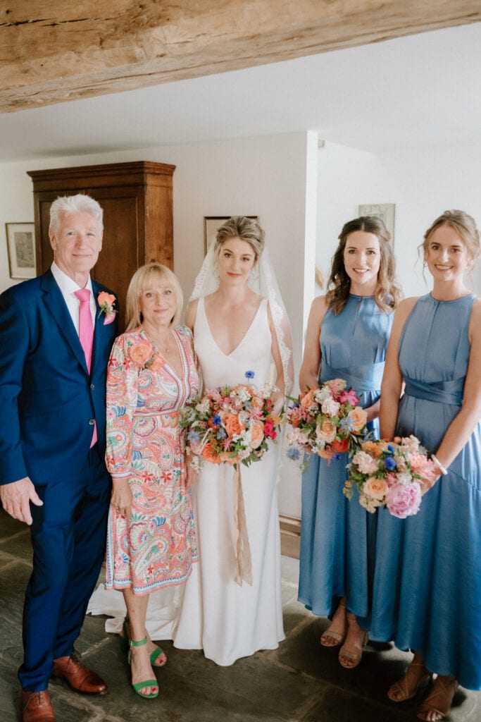 Bride with family and bridesmaids holding flower bouquets
