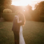 Couple embracing at sunset in a garden.