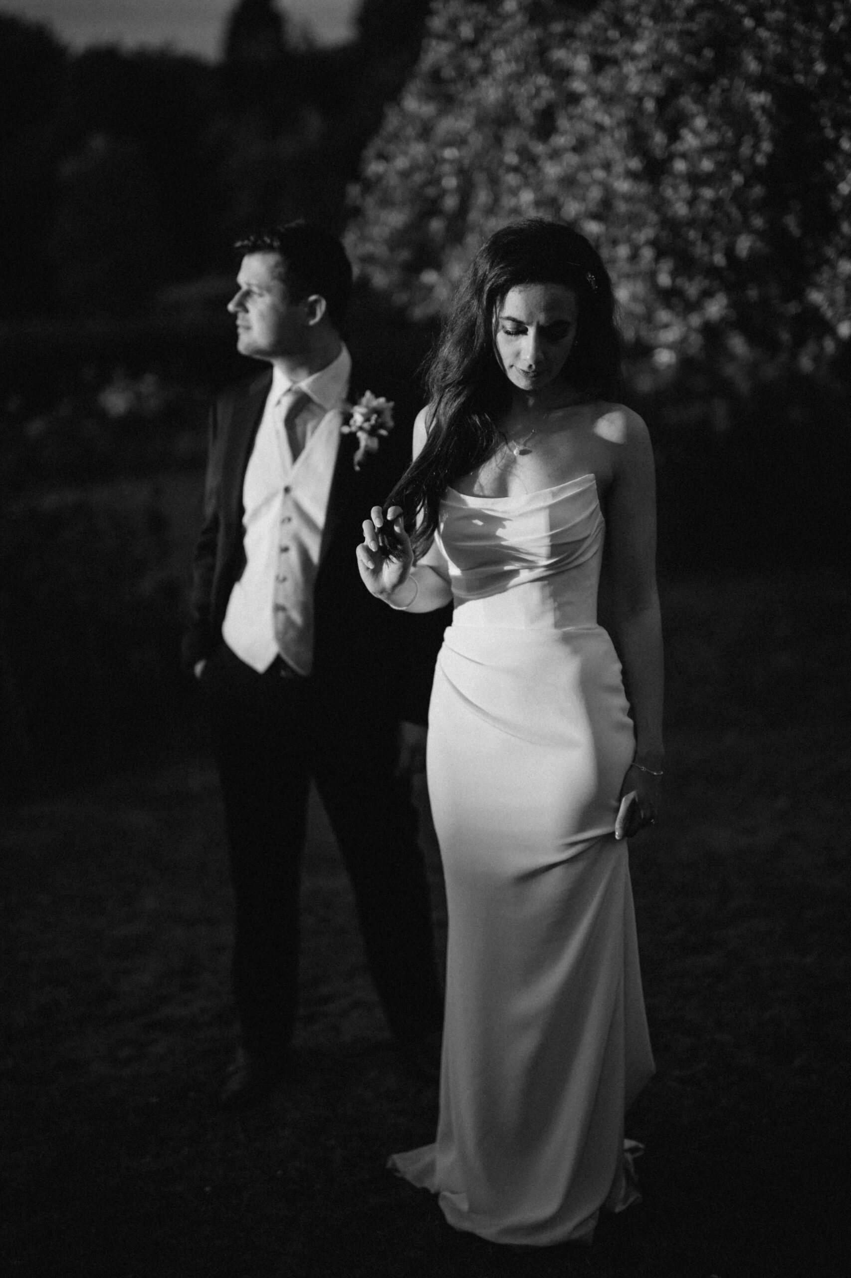 Couple in wedding attire at dusk.