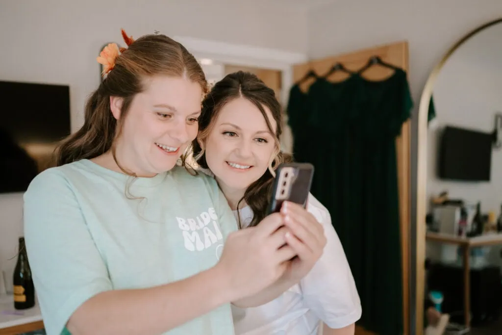 Bridesmaid and bride taking a selfie together.