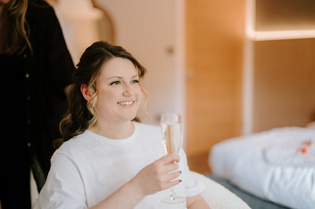 Smiling woman holding glass of champagne indoors.