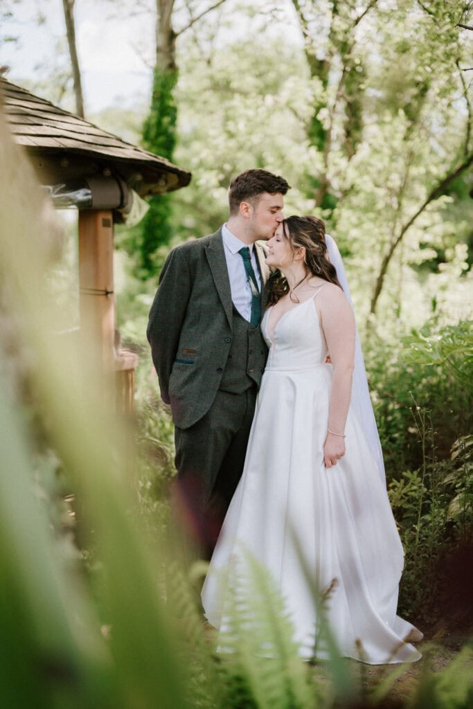 Bride and groom sharing a kiss outdoors.