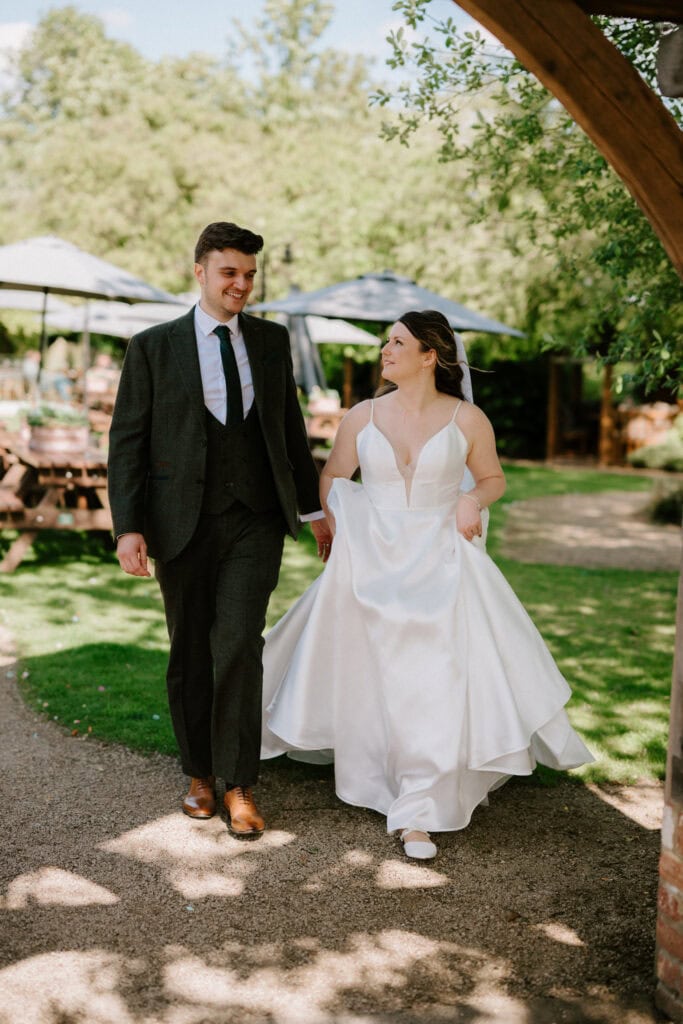 Bride and groom walking outside on wedding day.