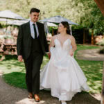 Bride and groom walking outdoors on wedding day.