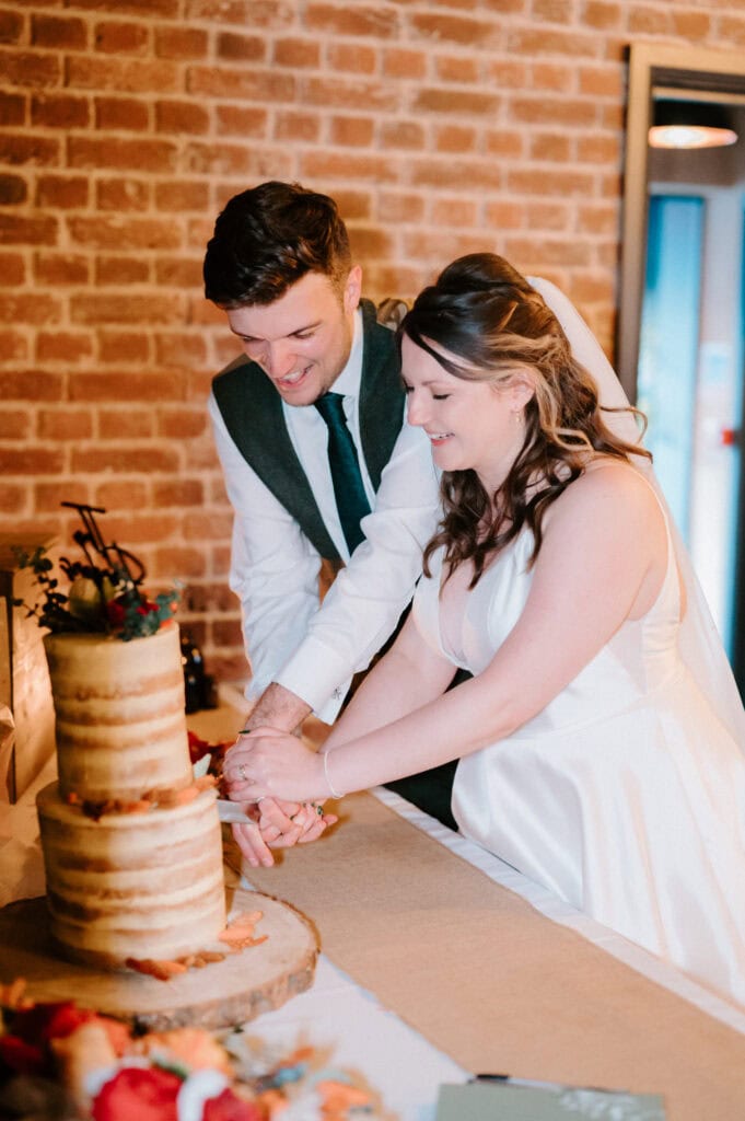 Bride and groom cutting wedding cake.