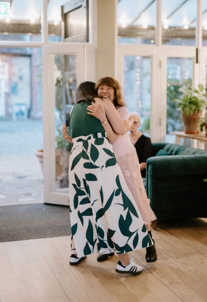 Two people hugging at an indoor event.