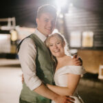 Happy couple embracing at night wedding reception.