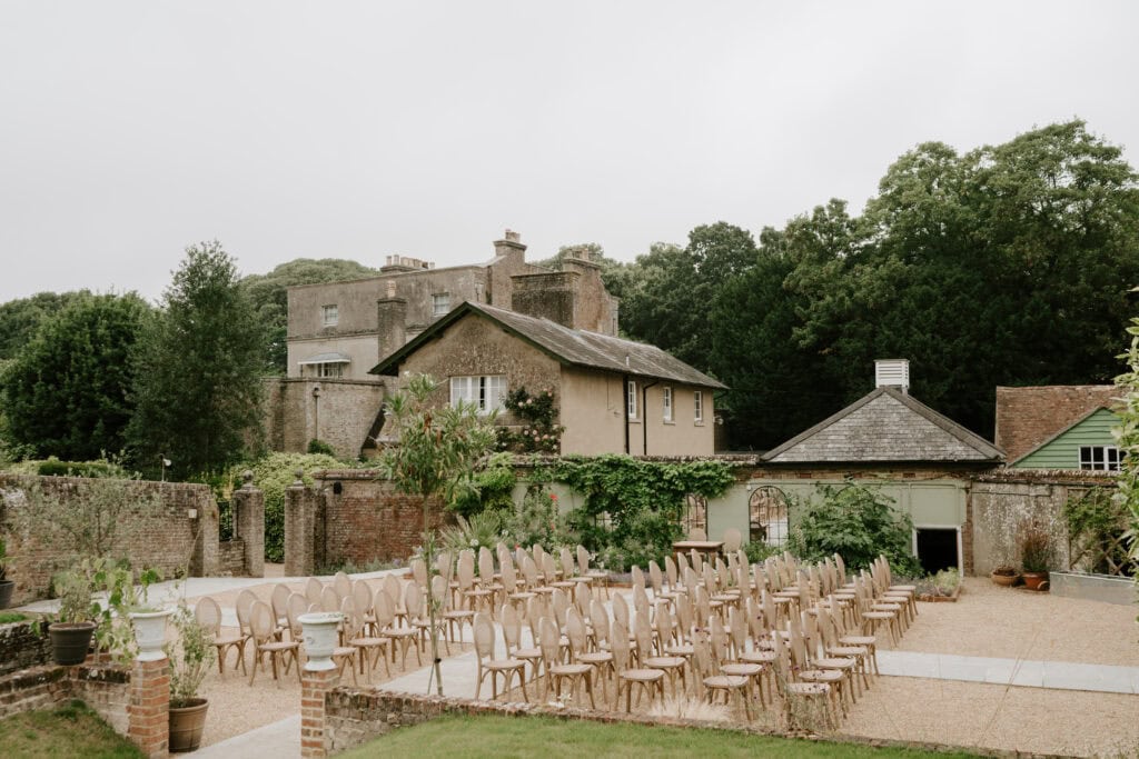 Outdoor wedding ceremony setup with chairs and greenery.