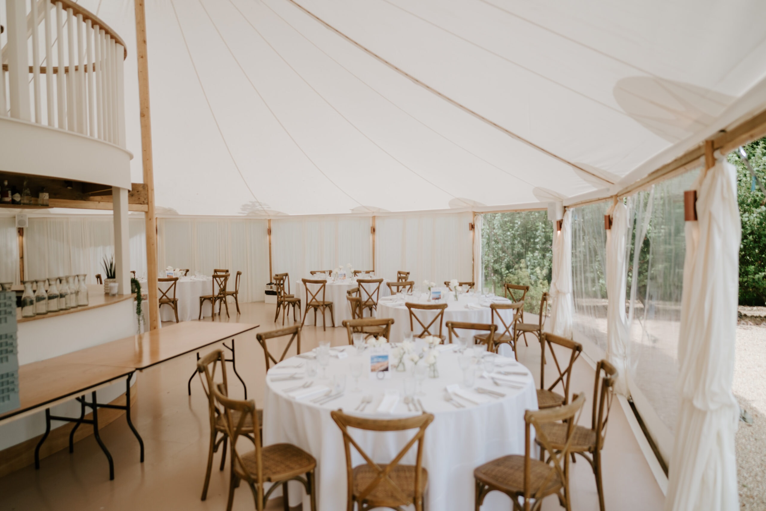 Elegant wedding reception inside a large white marquee.