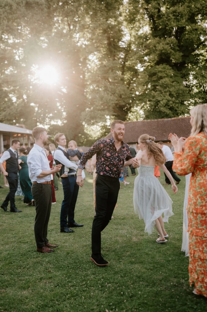 People dancing and enjoying a sunny outdoor event.