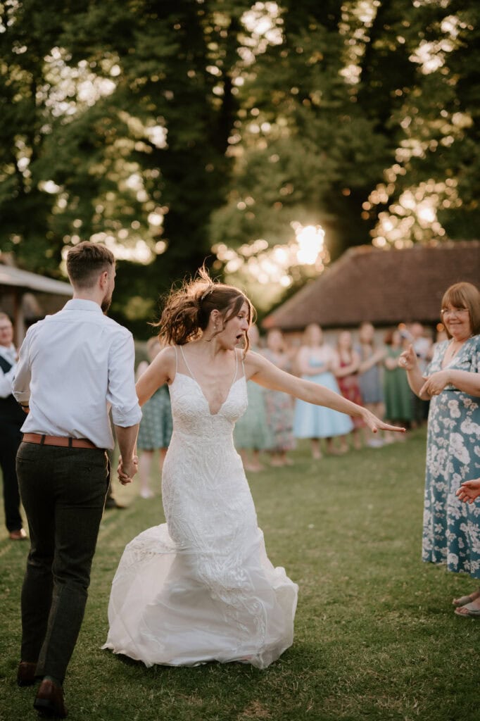 Bride dancing happily outside during wedding.