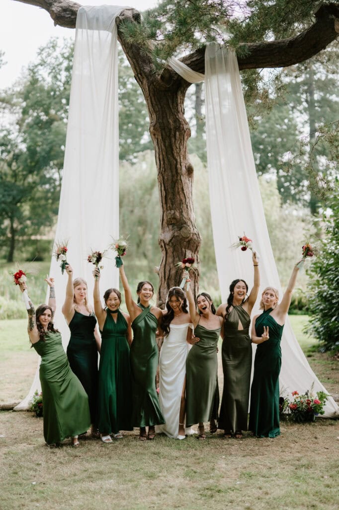 Bridesmaids in green dresses with the bride celebrating.