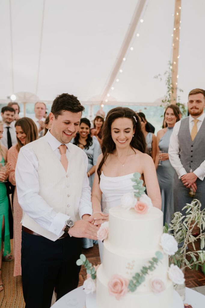 Couple cutting wedding cake at reception.