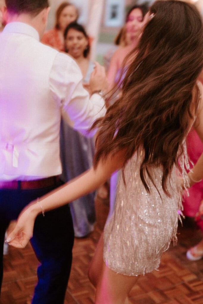 People dancing at a party in formal attire.