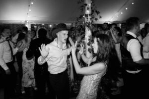 Wedding guests dancing energetically at lively reception
