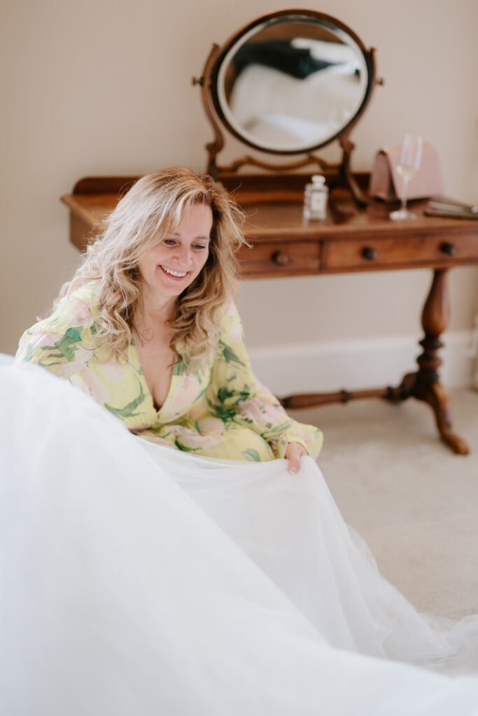 Smiling woman holding wedding dress, vintage vanity background.