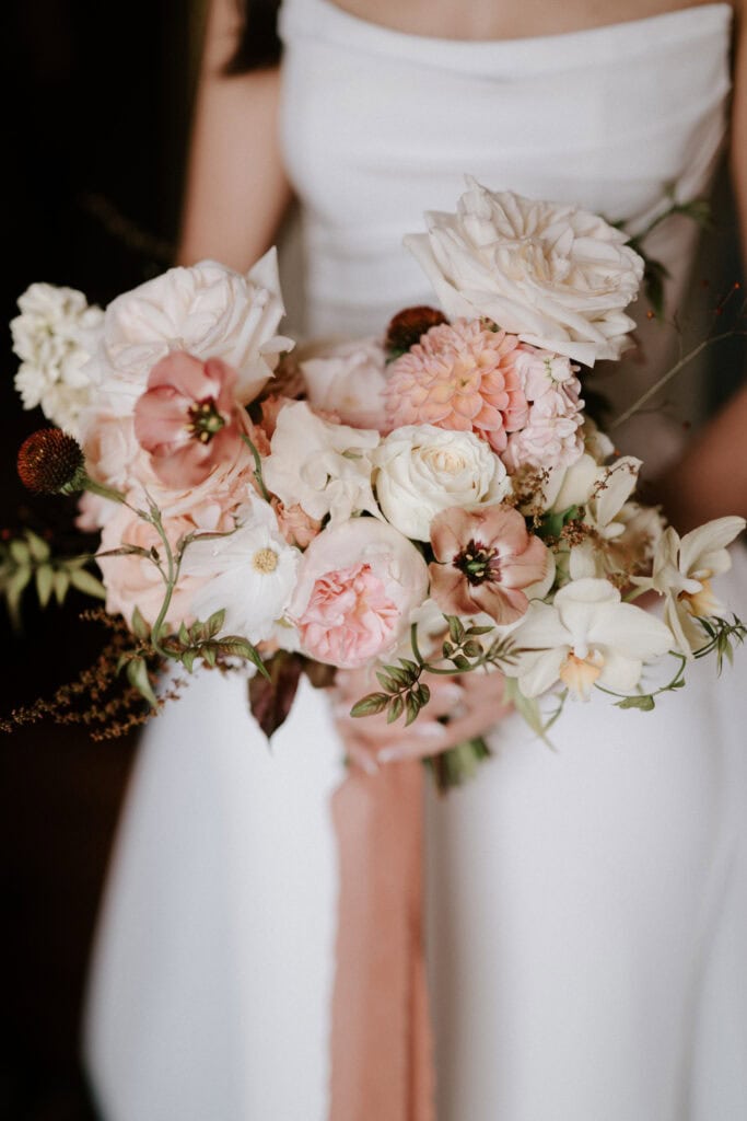 Bride holding pink and white flower bouquet.