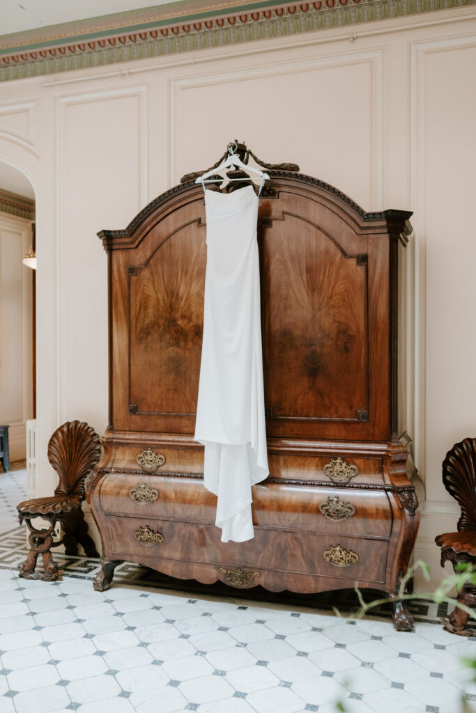 Elegant white dress hanging on antique wardrobe