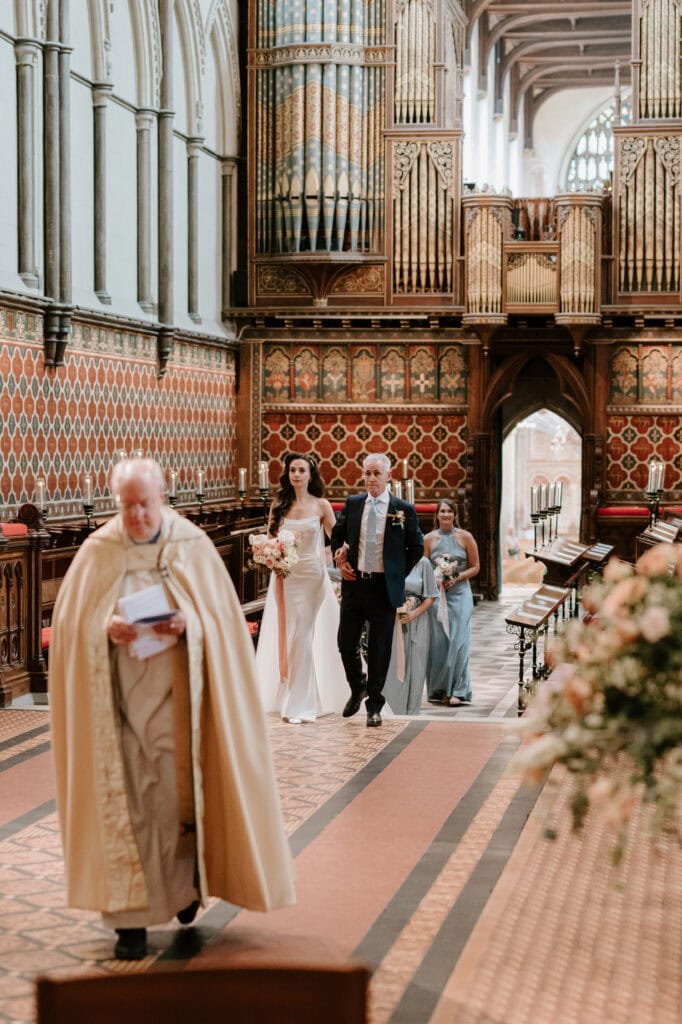 Bride and father walking down church aisle