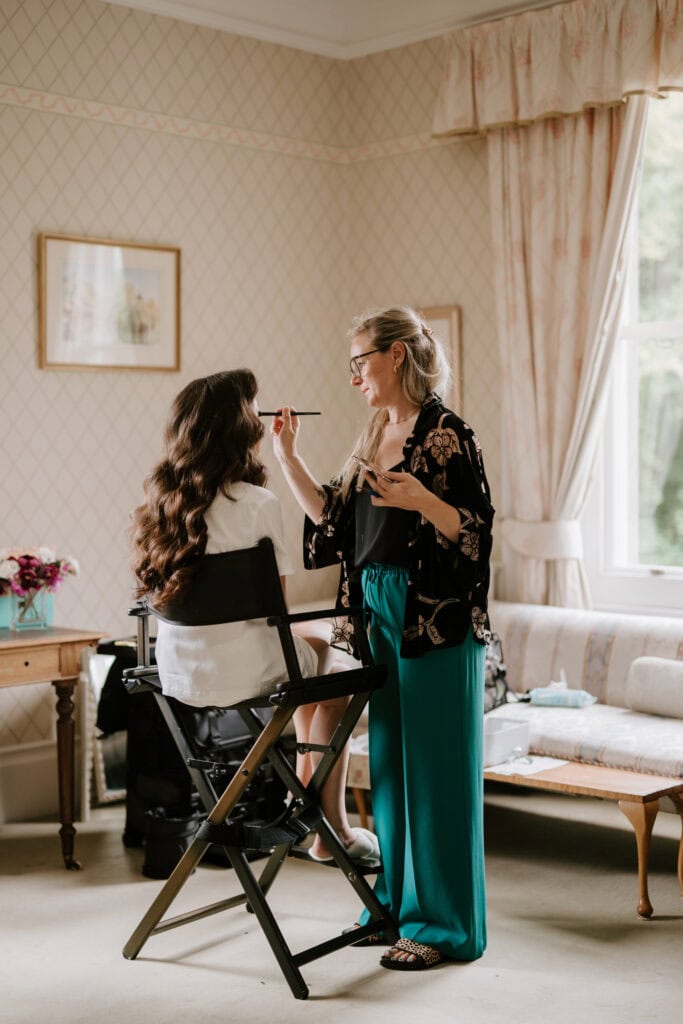 Woman getting makeup done in elegant room