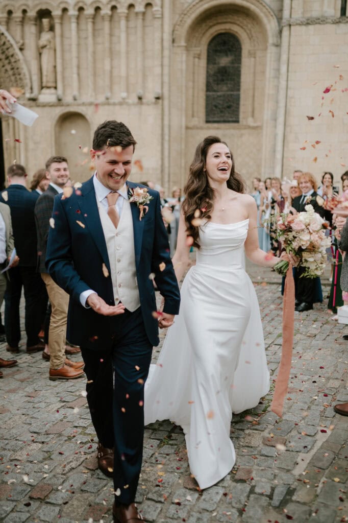 Bride and groom exiting church with confetti.