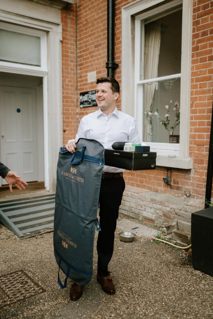 Man carrying suit bag and shoe box