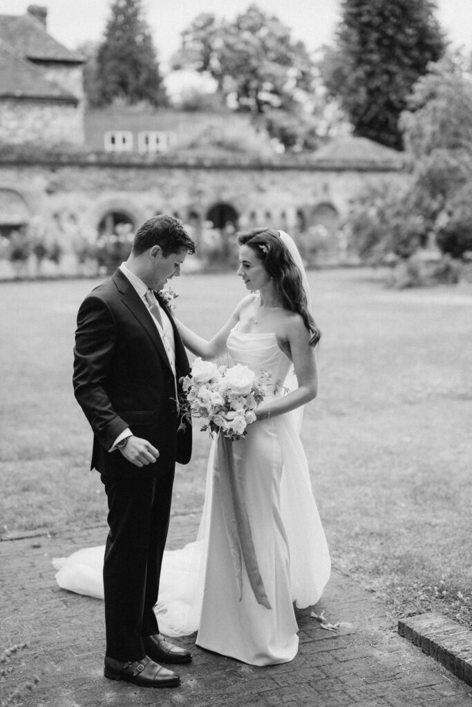 Bride and groom in a garden, holding flowers.