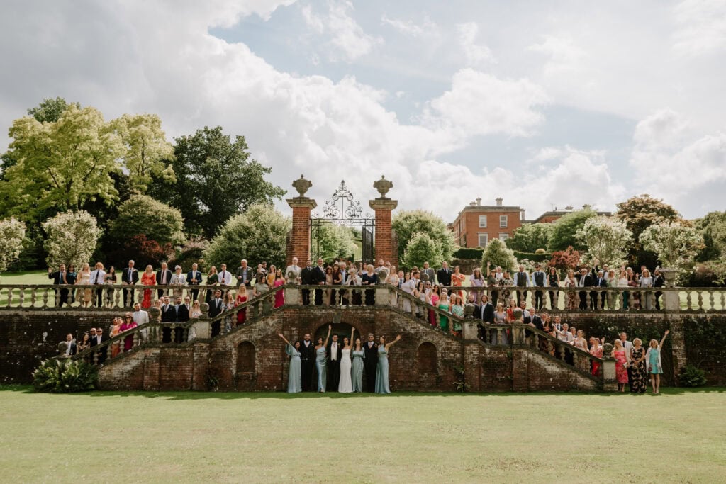 Large group photo at garden event with stone stairs.