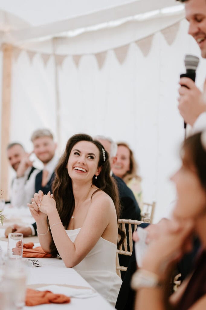 Smiling woman at wedding reception table.
