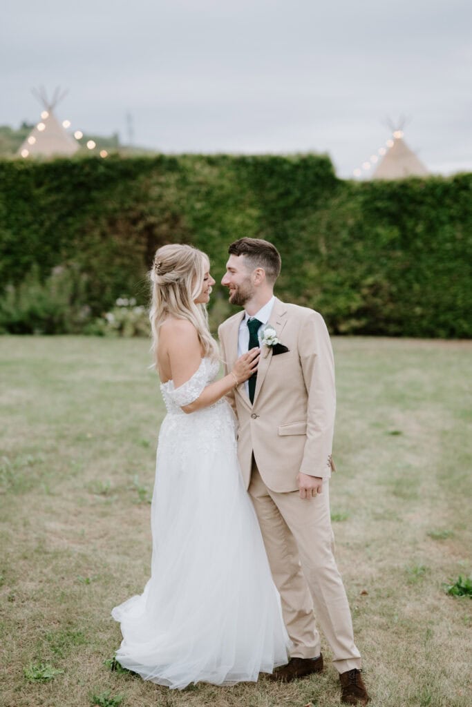Bride and groom in garden with tipis.